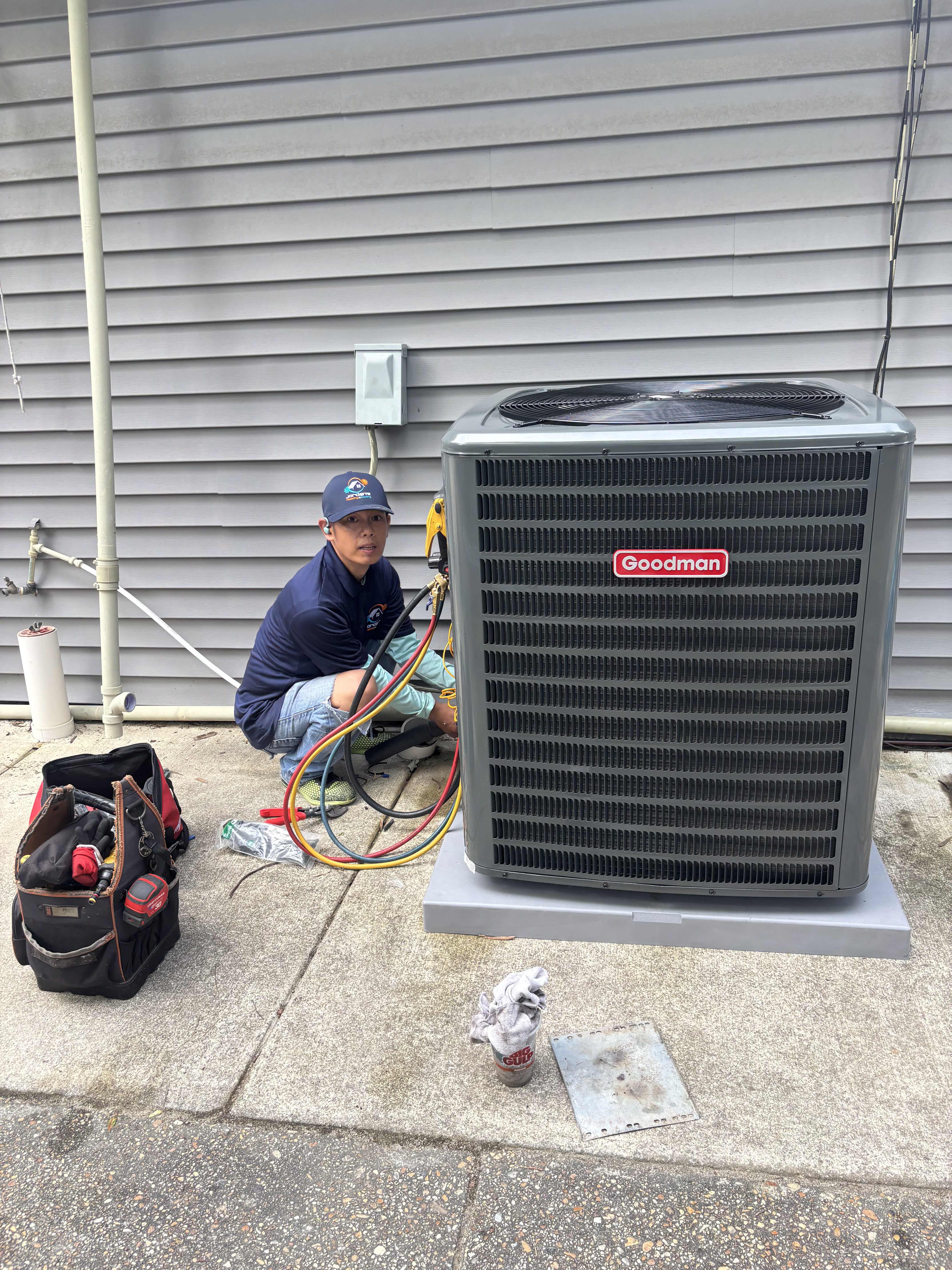 Jordan's Heating and Cooling owner servicing a Goodman AC unit in Hampton Roads